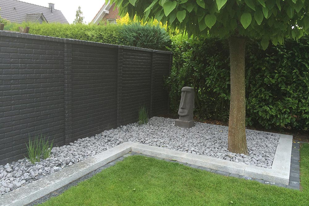 Betonzaun mit Ziegelsteinen in Gartenlandschaft