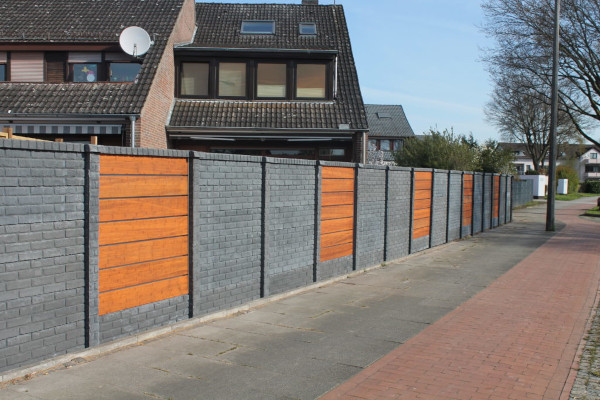 Betonzaun mit einer Holz-Metall-Kombination